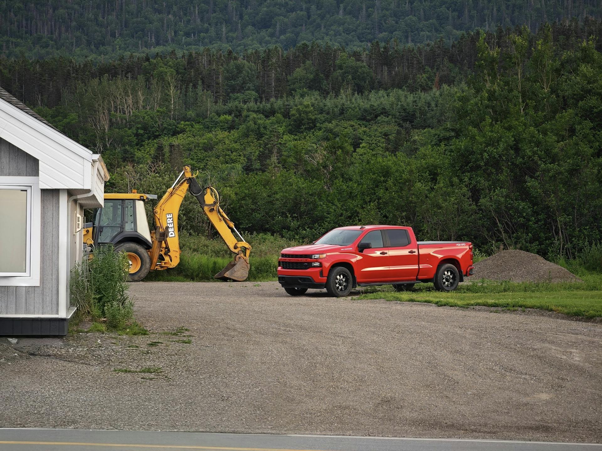 Red Truck and Backhoe in Forested Rural Area