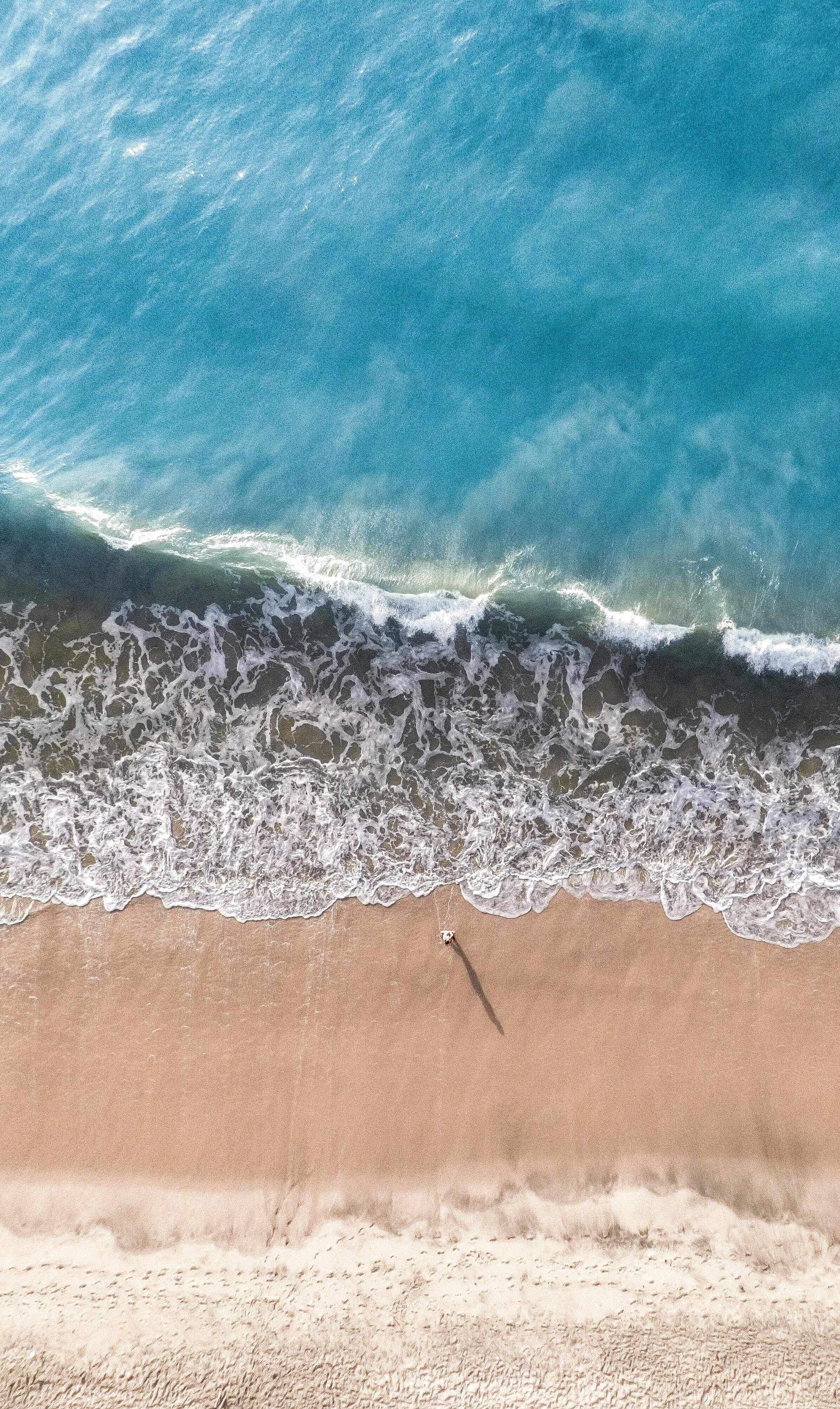 aerial photography of person standing on seashore