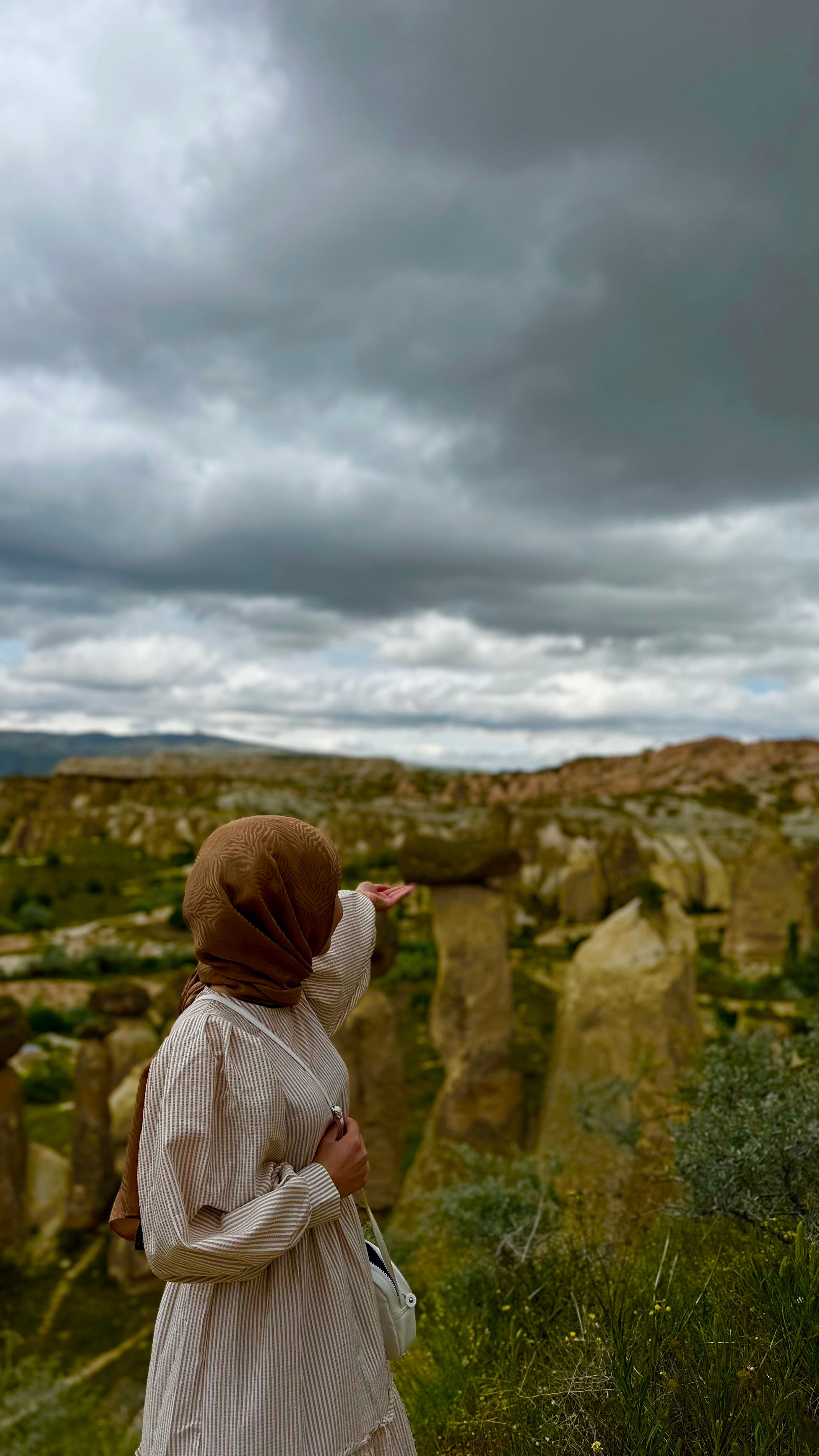 A woman in a hijab explores the iconic fairy chimneys in Nevşehir, Türkiye.