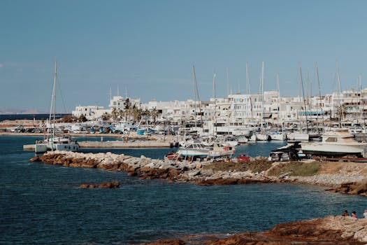 Serene view of Naxos marina with azure waters and traditional buildings in Greece.