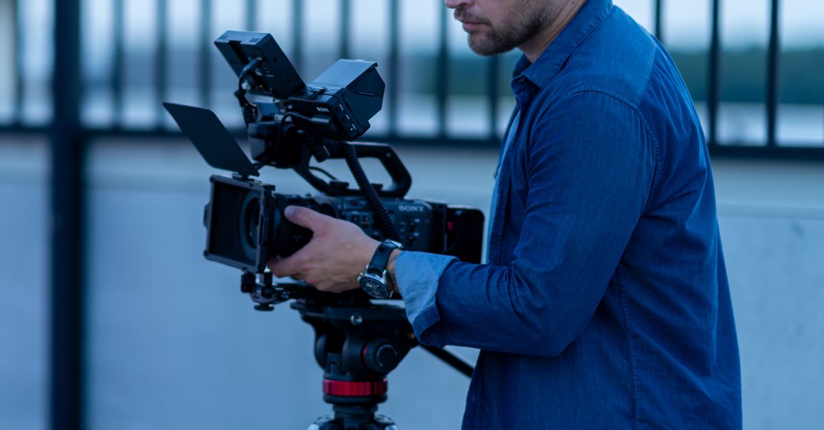 Operating A Camera Professional Filmmaker Operating Camera Outdoors · Free Stock Photo