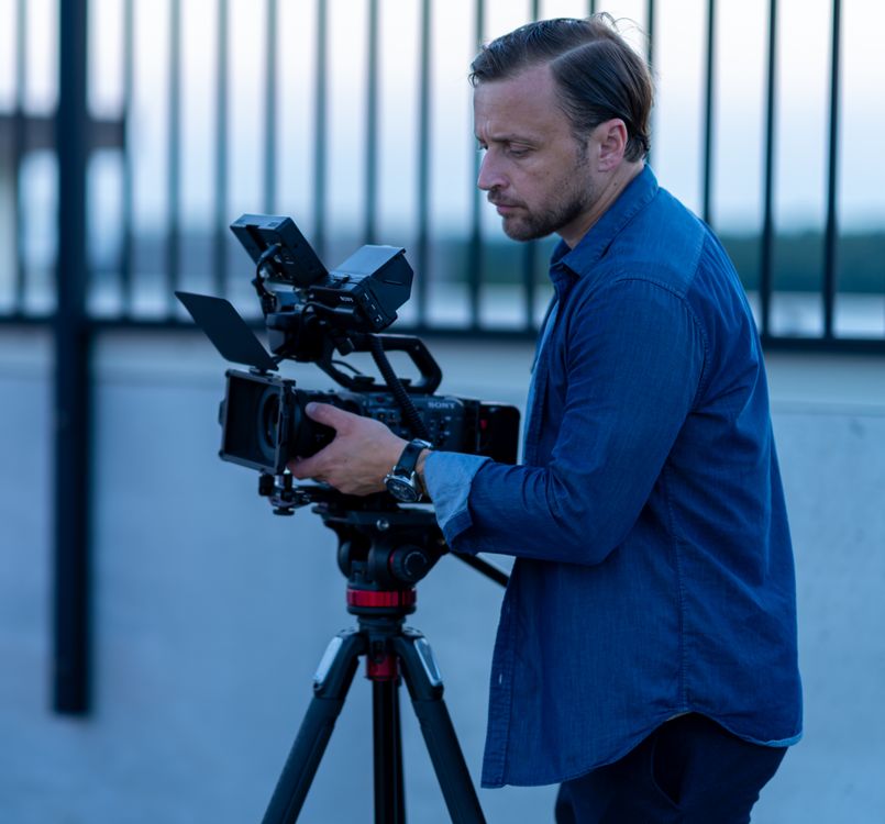 This image shows a professional filmmaker working outdoors.
