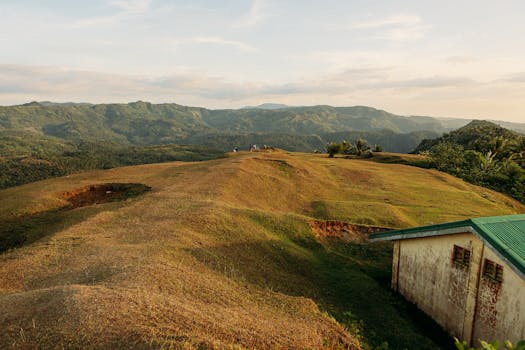 A picturesque landscape featuring rolling hills and vibrant countryside during sunset.