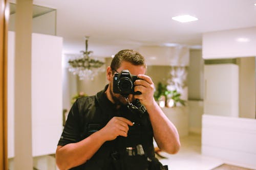 Man Using Black Dslr Camera