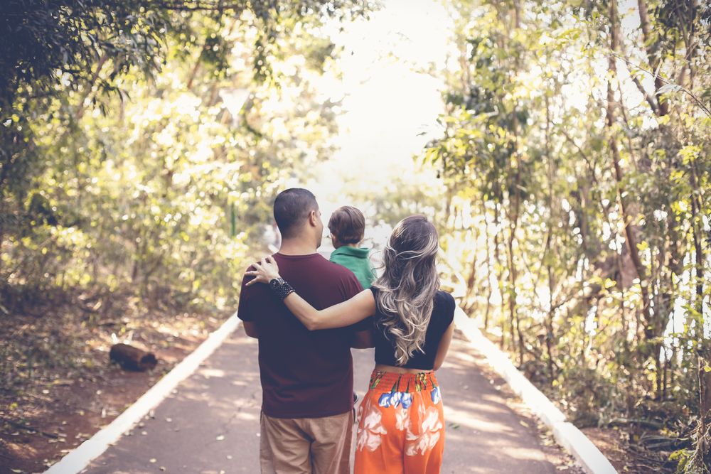 A family walking on a sunlit park trail
