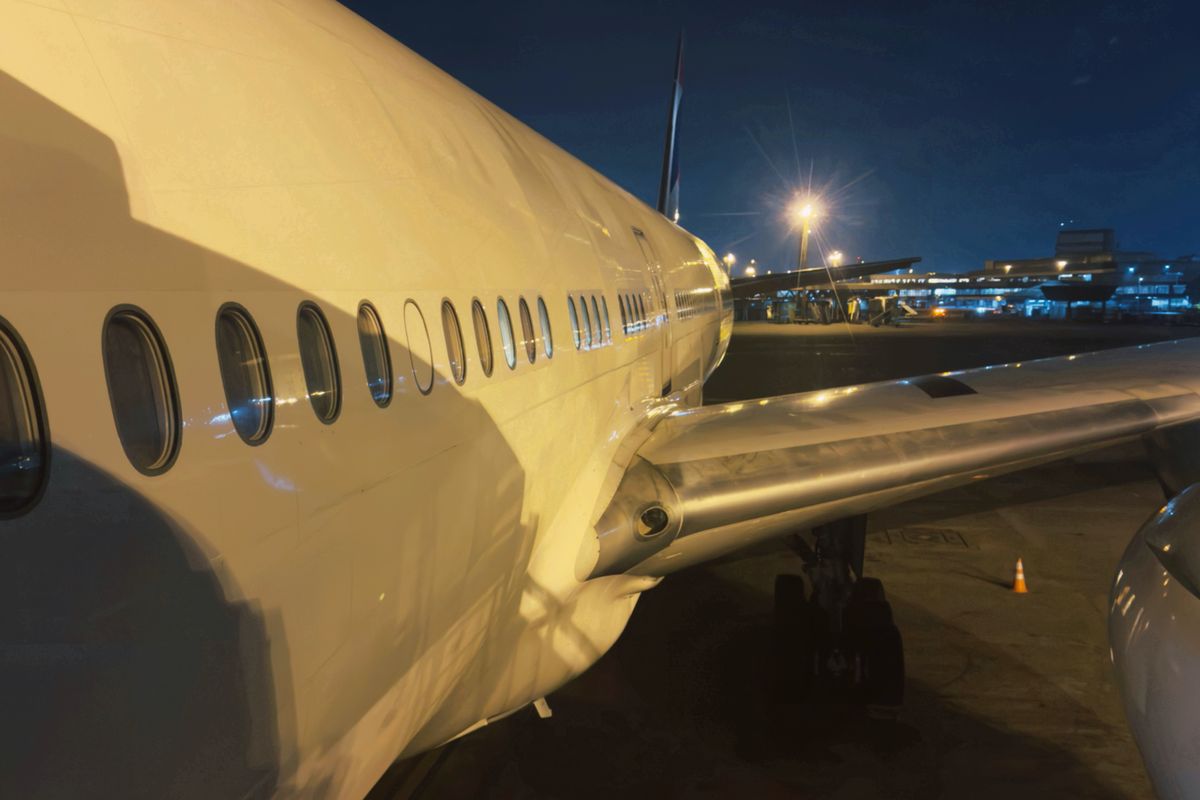 Aircraft wing lit at night seen from a cabin window
