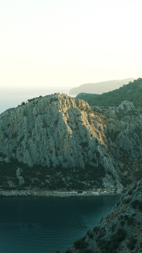 Free Tranquil view of rocky cliffs by the sea at sunrise, perfect for nature enthusiasts. Stock Photo