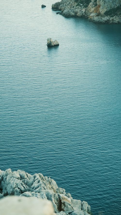 Free Peaceful view of a coastal seascape with rocks and calm waters, perfect for travel inspiration. Stock Photo