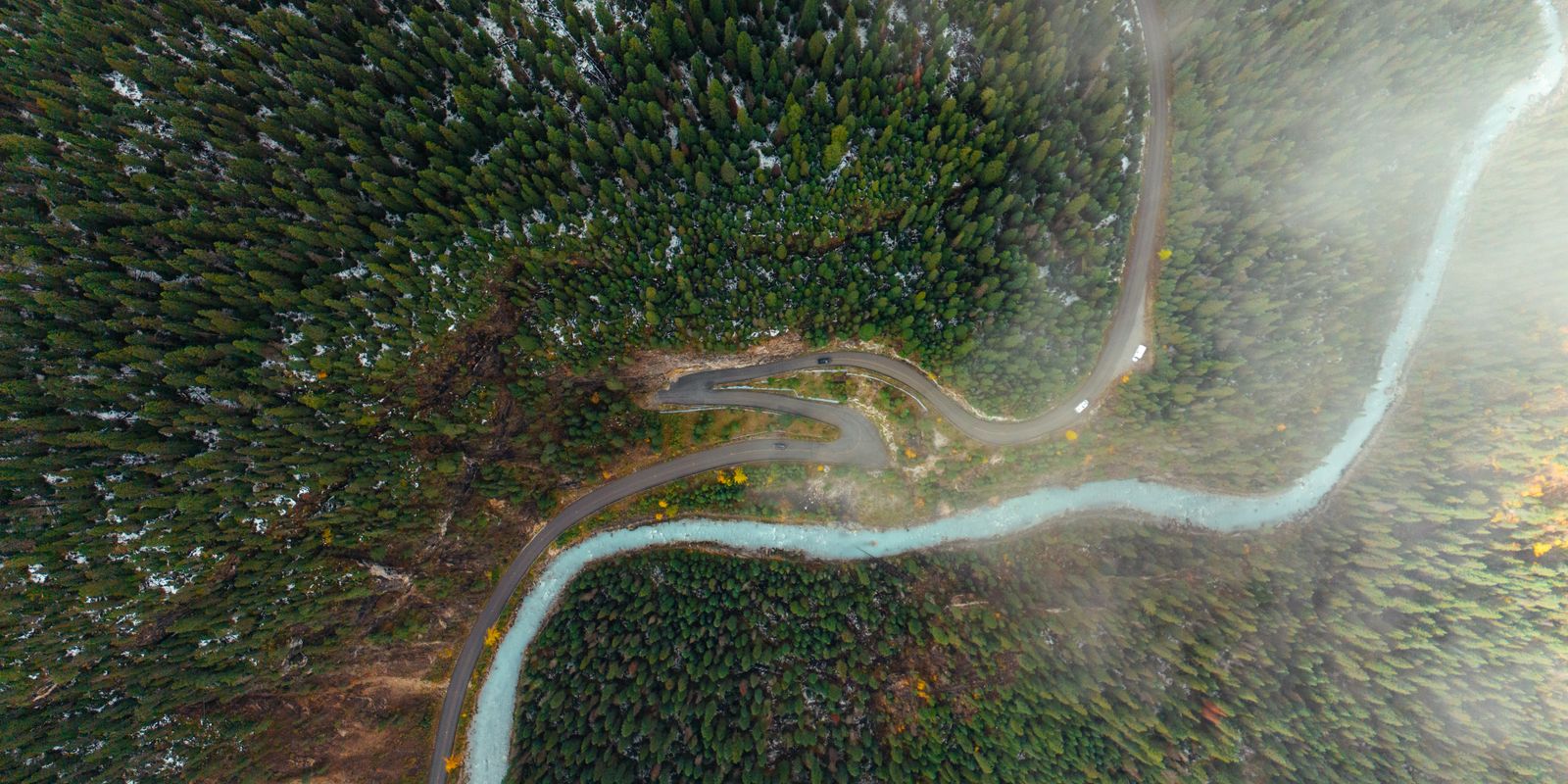 An aerial view of a river winding through forested mountains