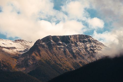 Free Stunning view of a snow-capped mountain under a blue sky with clouds. Stock Photo