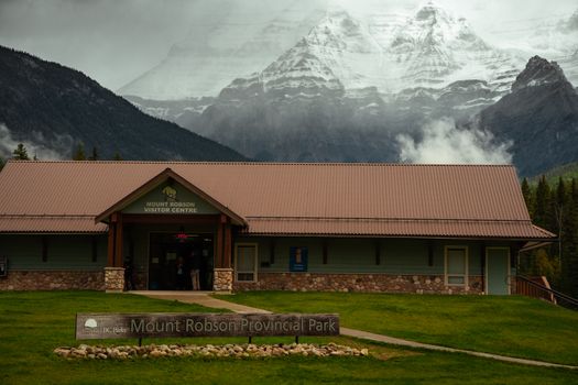 Mount Robson Visitor Centre in British Columbia, surrounded by mist and mountains, creates a moody landscape.