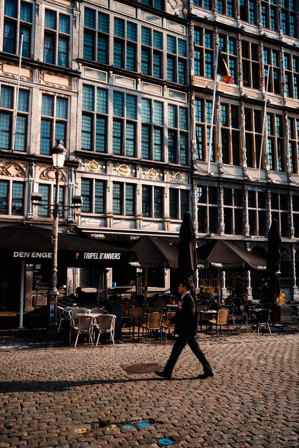 Trecător pe lângă o cafenea istorică din Anvers