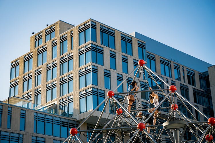 Women Climbs An Outdoor Symmetrical Structure