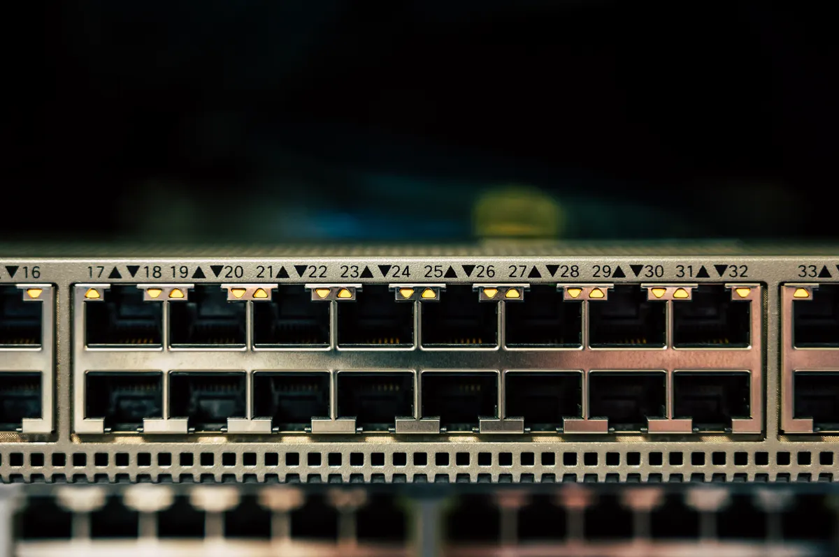 Close-up of a network switch with numbered ethernet ports and small amber status lights.