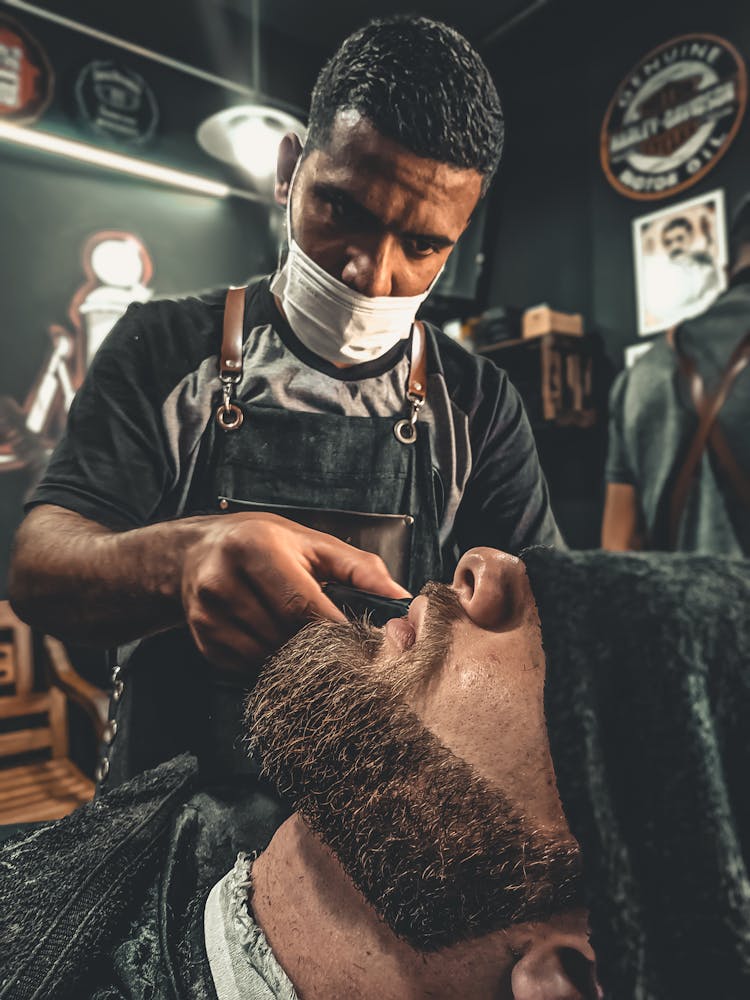 A Barber Grooming A Man's Beard