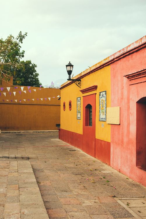 Free Colorful colonial buildings in a peaceful street in Oaxaca, capturing Mexican architectural essence. Stock Photo