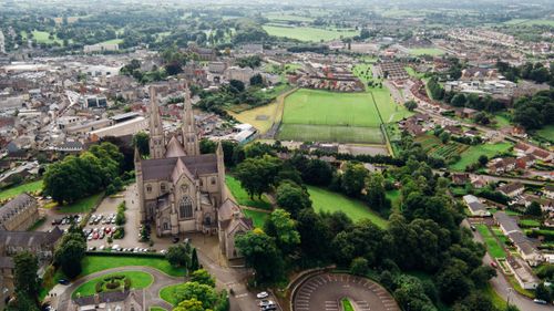 Free A breathtaking aerial view of a cathedral and lush surrounding landscape in a quaint town. Stock Photo