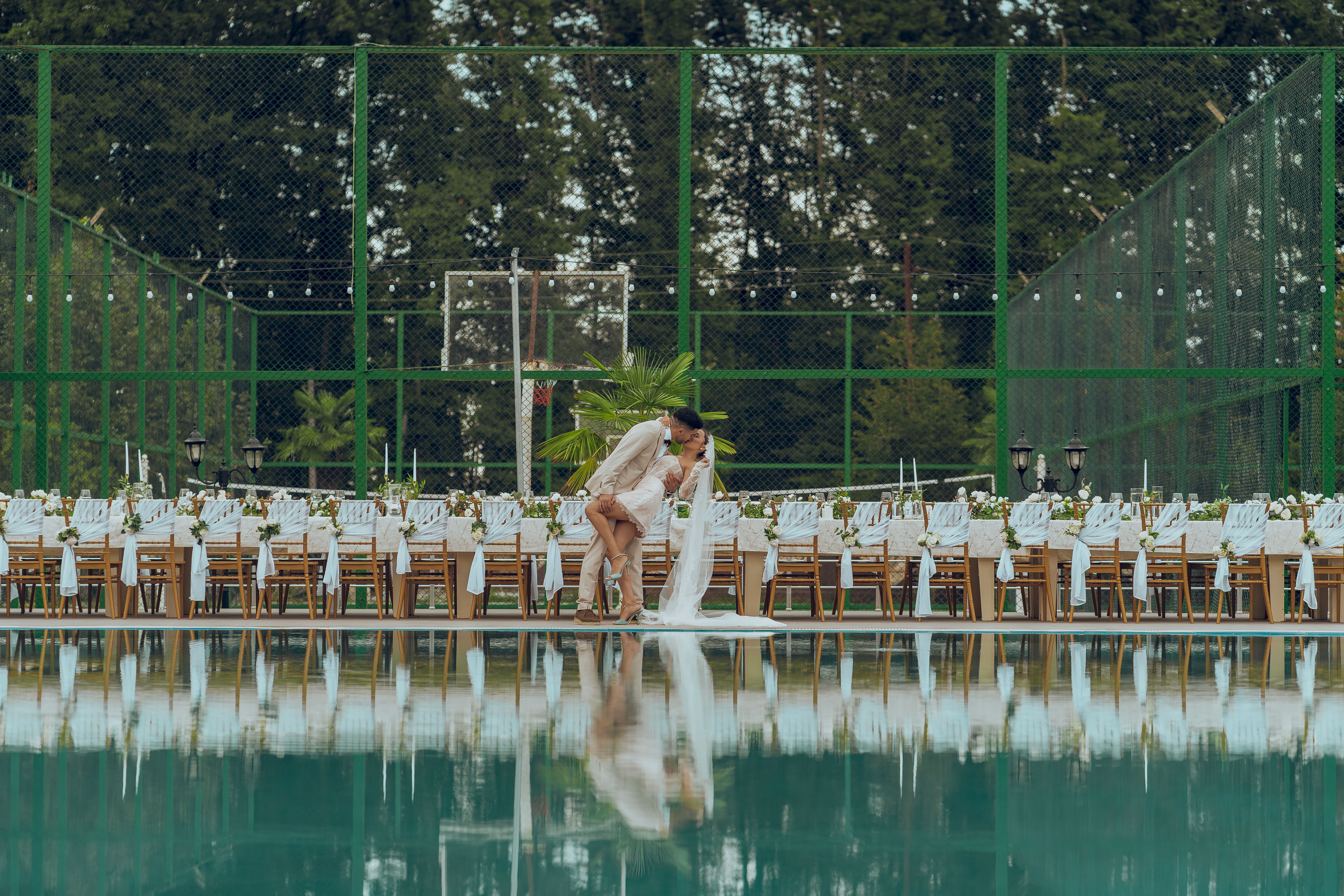 A couple embracing at an elegant outdoor wedding reception by the pool. - Photo by Eko Agalarov on Pexels