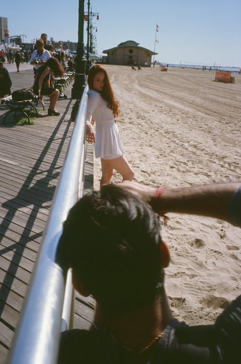 Photo of Woman Wearing White Dress and a Man Taking Photo Using Black Dslr Camera