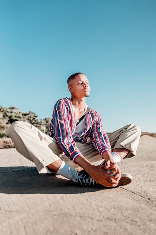 Free Man Sitting On Concrete Pavement Stock Photo