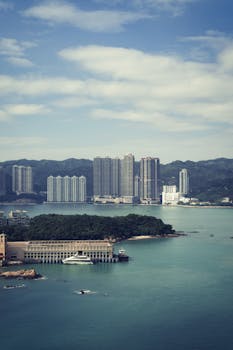 A scenic view of a coastal cityscape with skyscrapers and yachts on a sunny day.