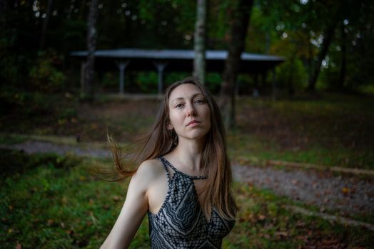 Portrait of a woman outdoors in a natural forest setting, captured at twilight with a serene expression.