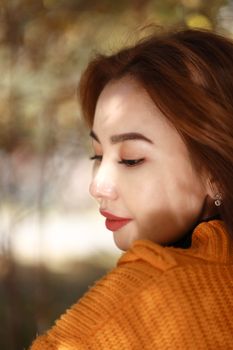 Close-up portrait of a woman in a cozy autumn sweater, featuring gentle shadow play.