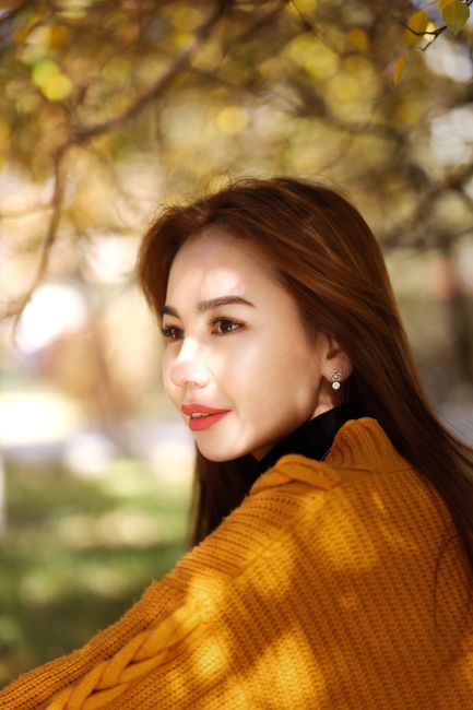 Captivating portrait of a woman in autumn settings, embraced by warm tones.