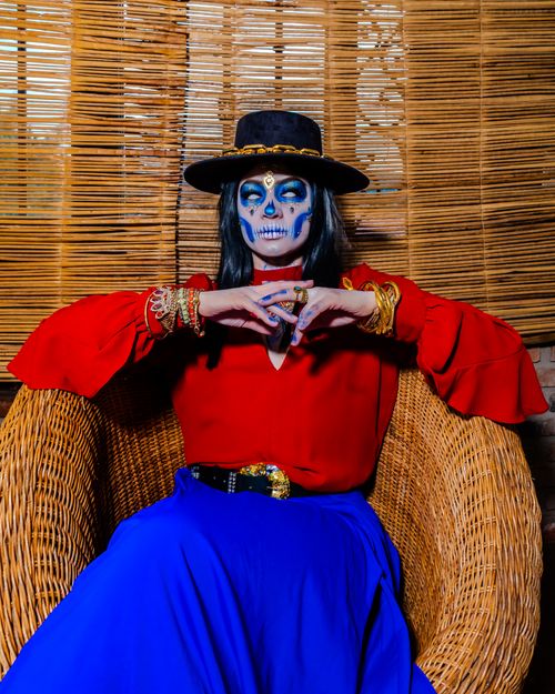 Free Portrait of a woman in Catrina makeup, celebrating Dia de los Muertos in vibrant attire. Stock Photo