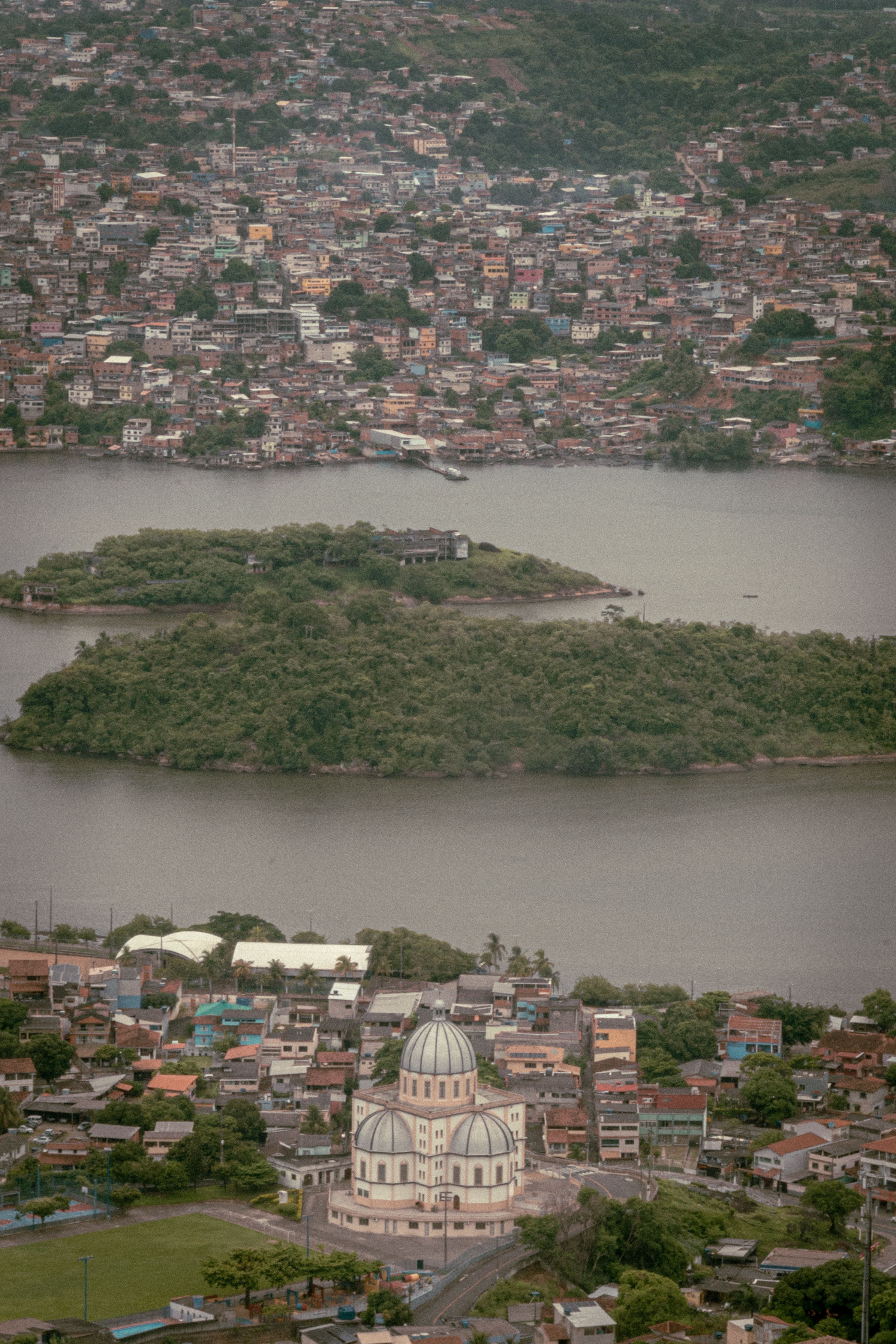 An aerial view of Vitoria, ES, Brazil showcasing the iconic church amidst lush greenery and vibrant cityscape.