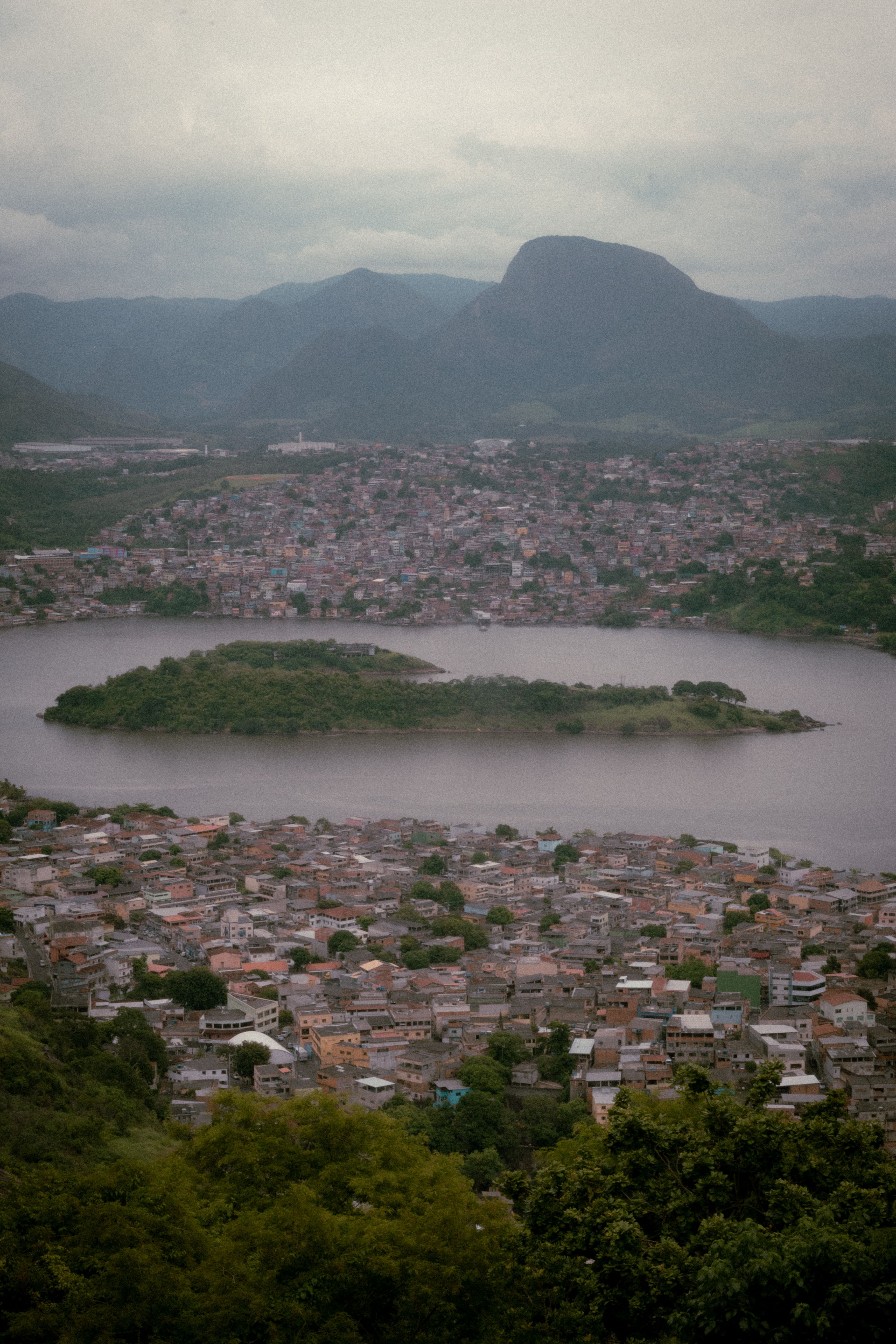 Aerial view of Vitoria, Brazil, showcasing the cityscape, lake, and mountains.