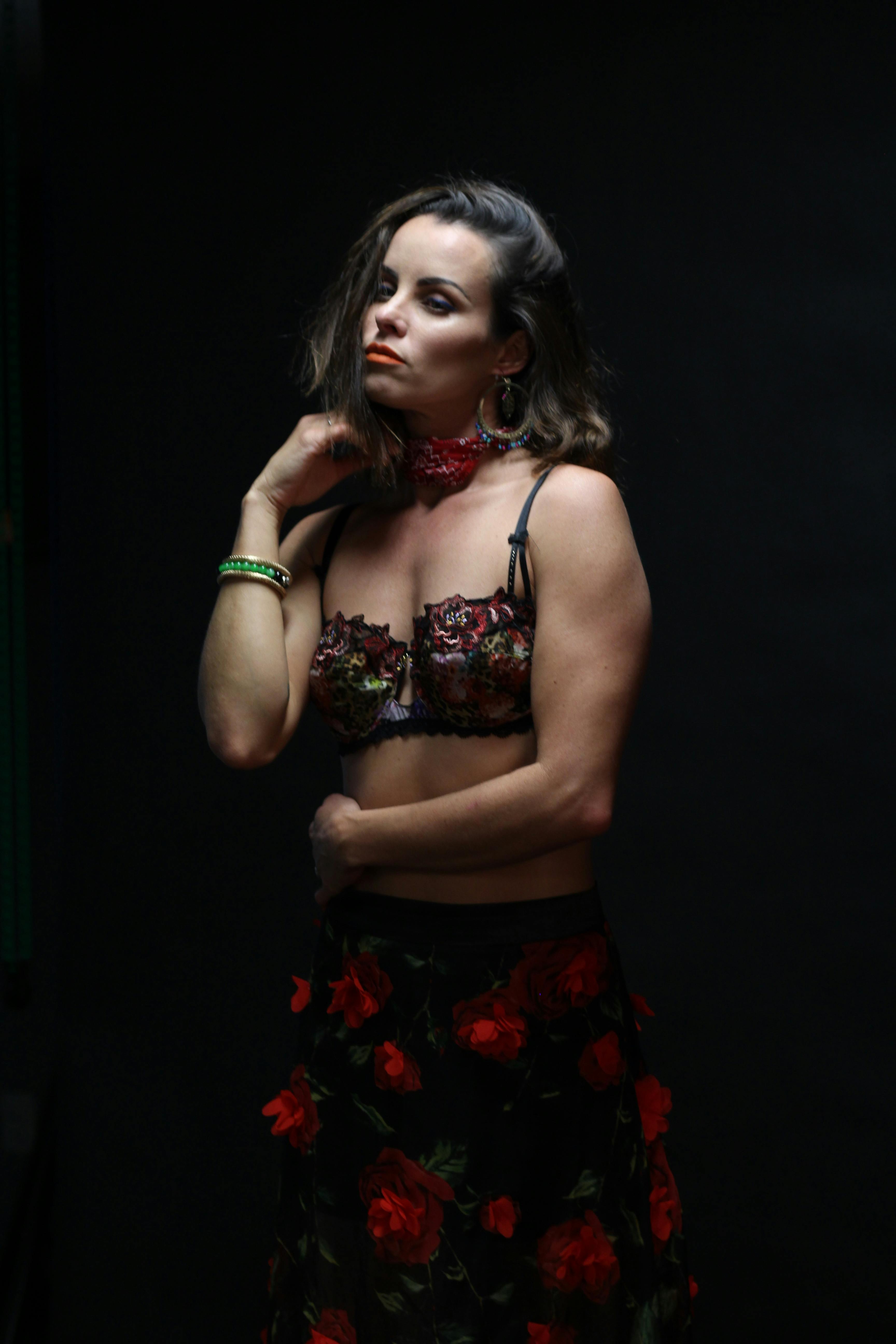 Ücretsiz Siyah Arka Plan Yanında Duran çiçek Elbiseli Kadın Stok Fotoğraflar