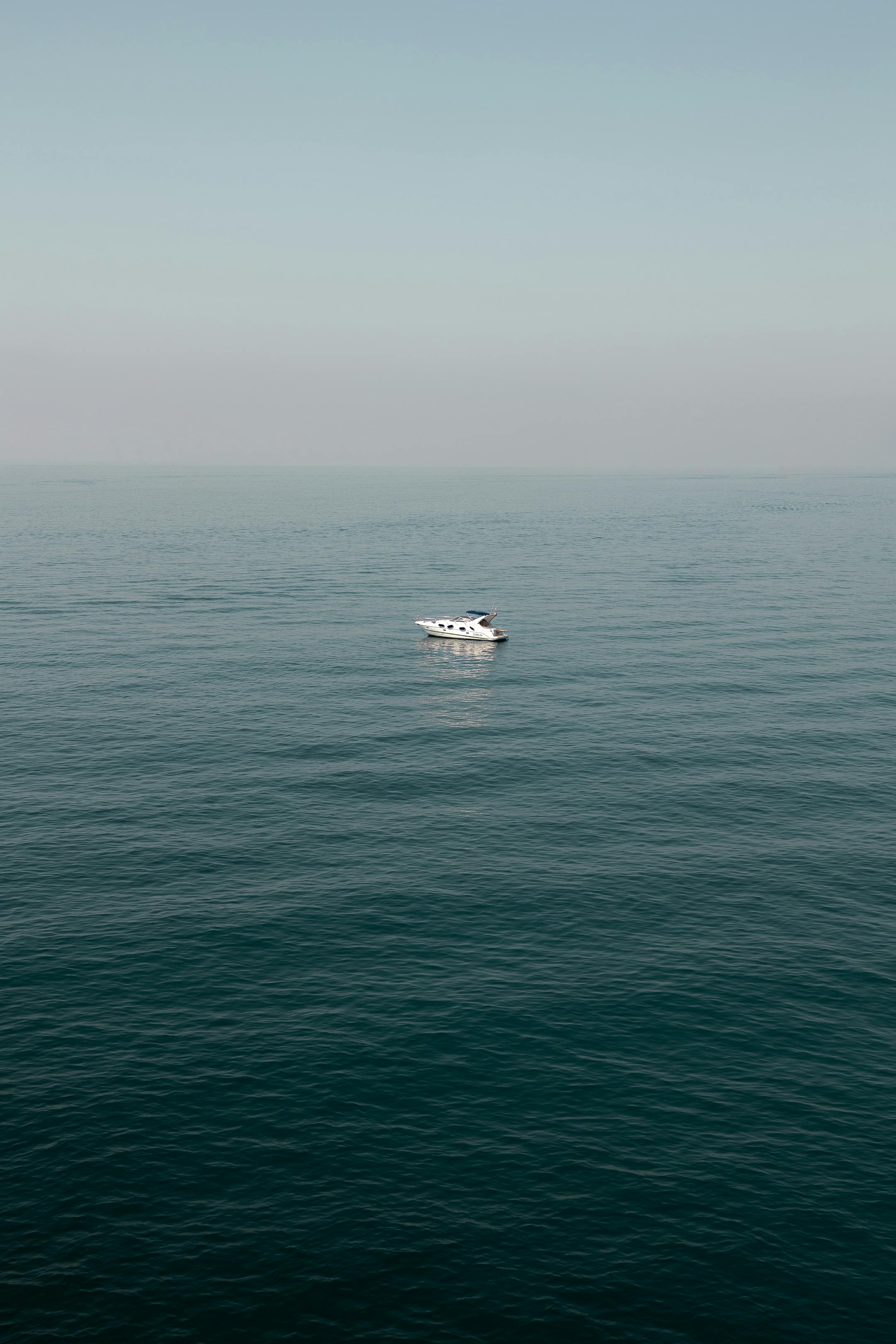 A serene view of a solitary boat on the calm sea near Cinqueterre, Italy.