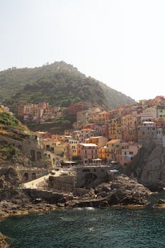 Stunning view of colorful houses in Manarola, Cinqueterre, Italy, surrounded by cliffs and sea.