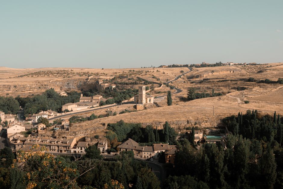 Vista aérea de un pueblo rural histórico en España con tonos cálidos de verano.