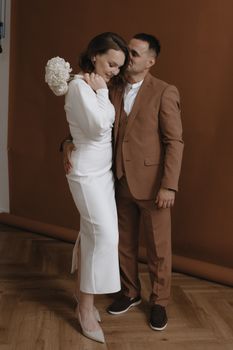A couple in elegant formal wear standing together, showcasing romance and style.