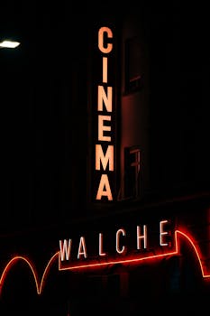 Neon-lit vintage cinema sign "Walche" glowing at night, evoking classic theater ambiance.