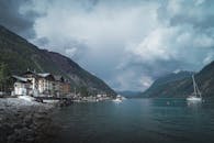 帆船、码头和多云的天空，与美丽的山湖风景相映成趣