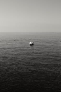 Peaceful view of a single boat on the vast ocean near Cinqueterre, Italy.