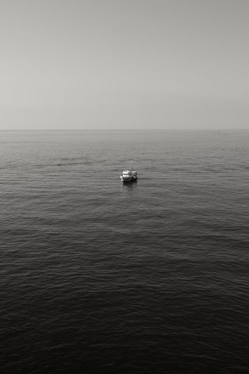 Free Peaceful view of a single boat on the vast ocean near Cinqueterre, Italy. Stock Photo