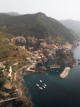 Stunning aerial view of Cinque Terre, Italy with vibrant blue sea and rustic buildings.