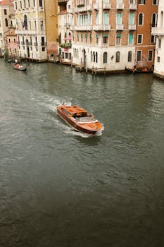 Classic Venetian scene of a motorboat navigating the canals surrounded by historic buildings.