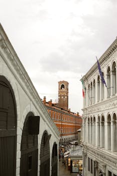 View of historic architecture in Venice with bell tower and flags.