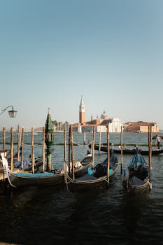Serene gondolas docked at St. Mark's Basin, Venice, with iconic San Giorgio Maggiore in the background.