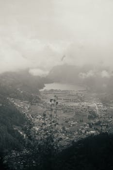 A serene aerial vista of Saint Moritz with misty mountains and a lush valley.