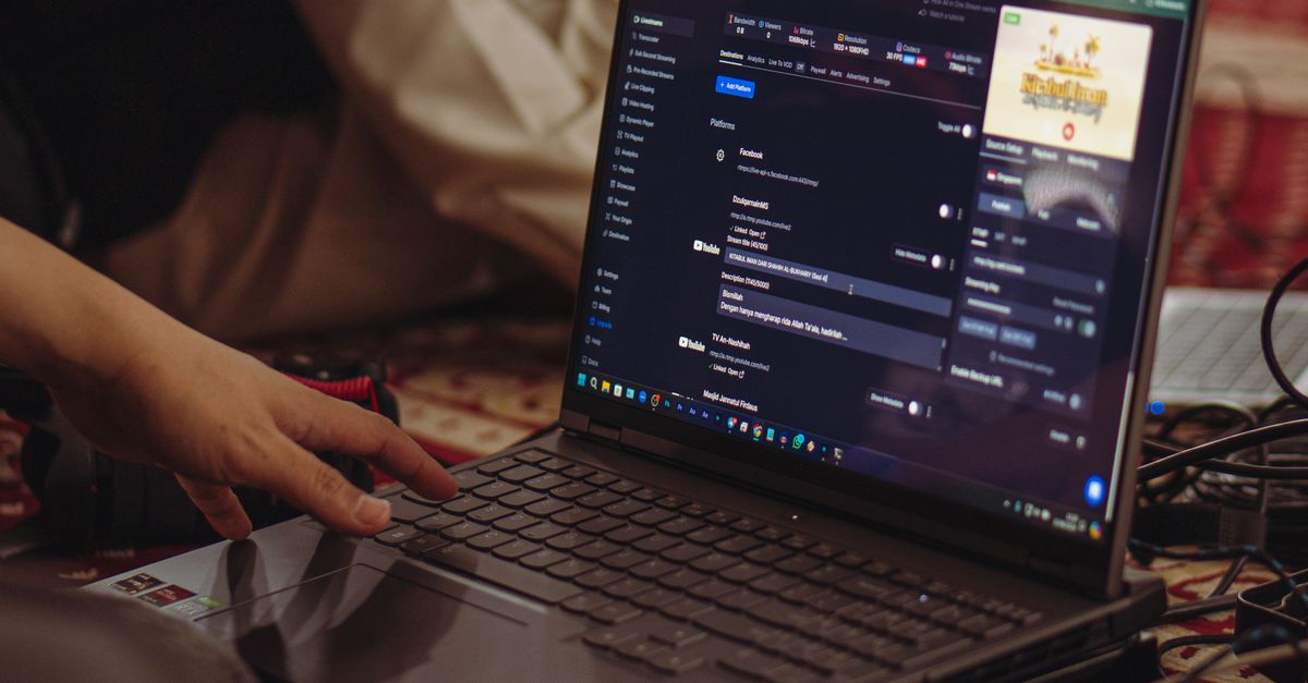A person setting up a live stream on a laptop, emphasizing technology and connectivity.