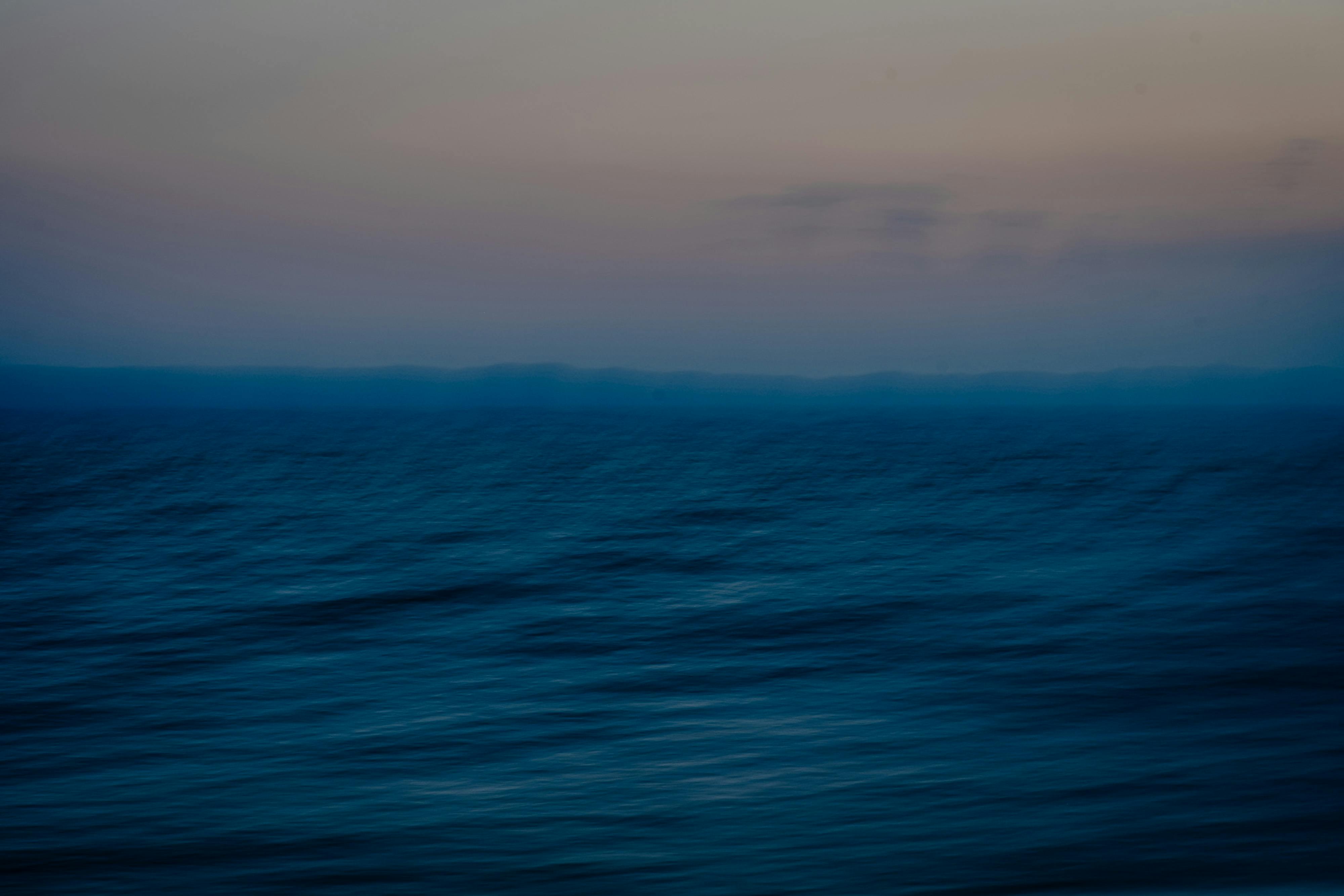 Abstract view of a calm ocean under a twilight sky with soothing colors.