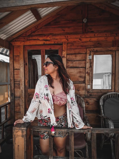 Woman Standing Beside Railing On A Veranda