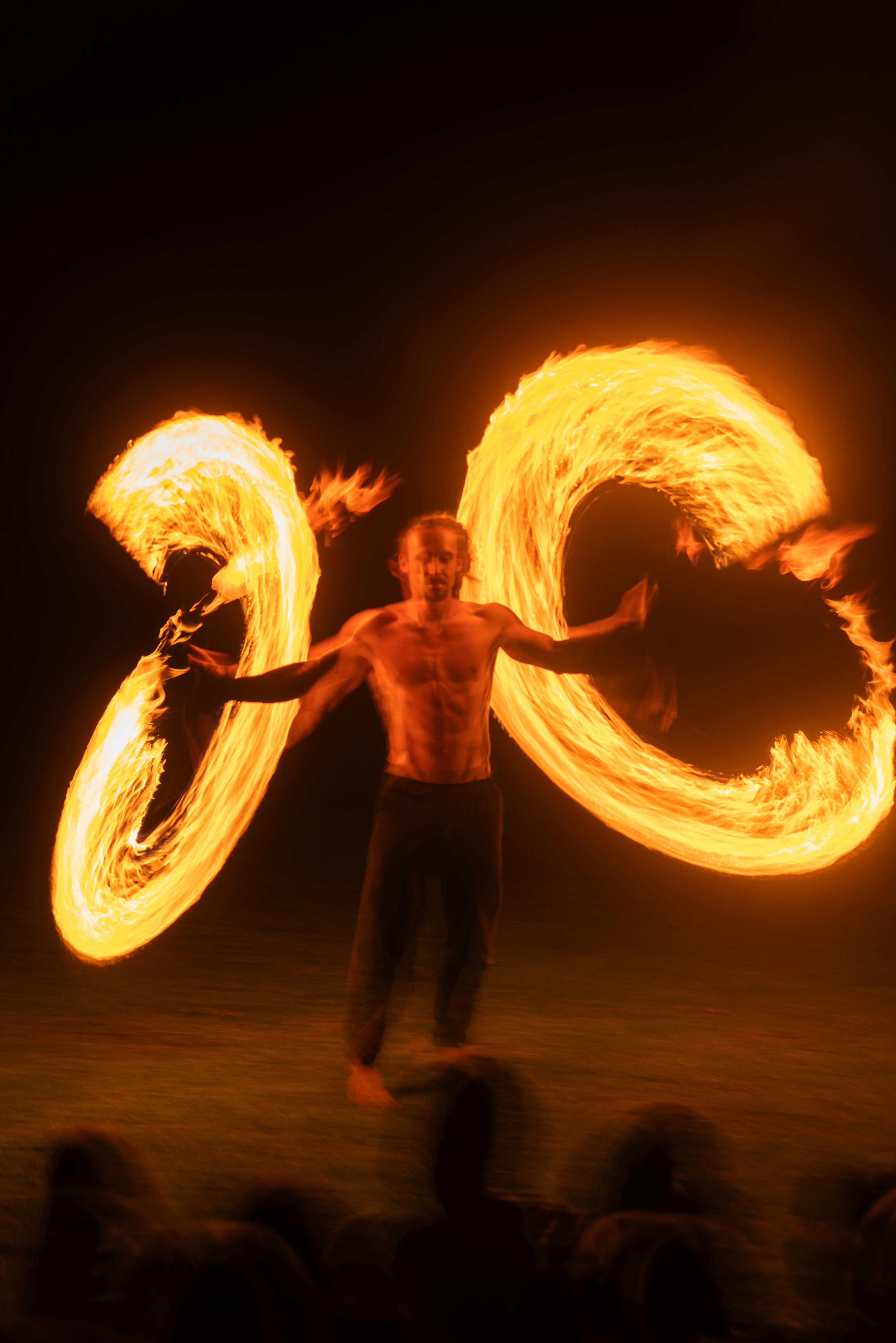 A captivating fire dance with a performer creating vivid light trails against a dark backdrop.
