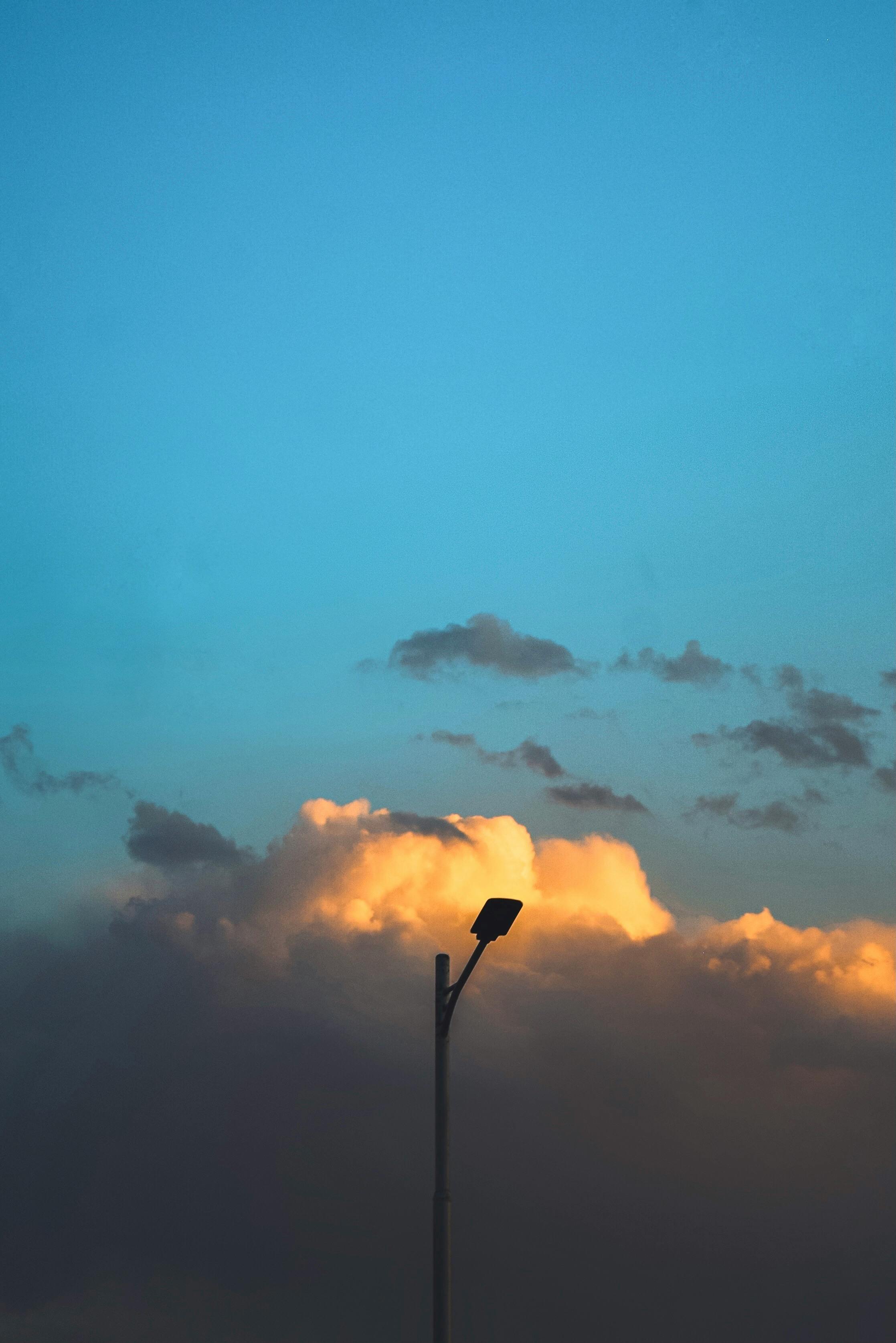 Street lamp silhouetted against a vivid and dramatic evening sky with clouds.